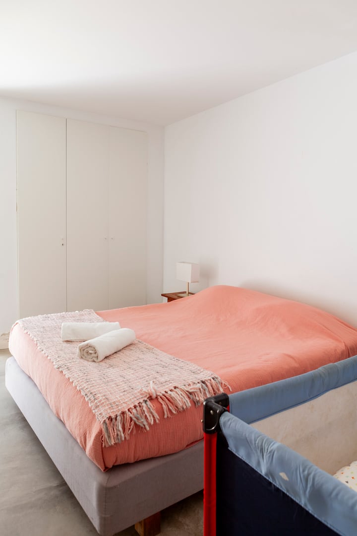 Habitación doble en el primer piso de la casa, con cama matrimonial y cuna.