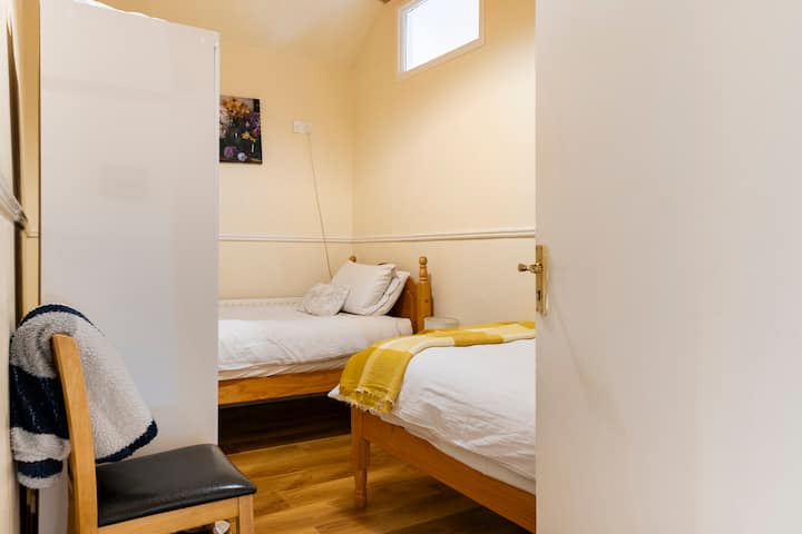 Dormitorio central, desde la puerta, 2 camas individuales (Amer. twins), (sin ventanas exteriores).