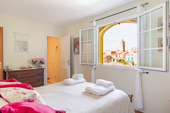 El dormitorio principal con baño privado tiene vistas al jardín trasero y al antiguo centro del pueblo.