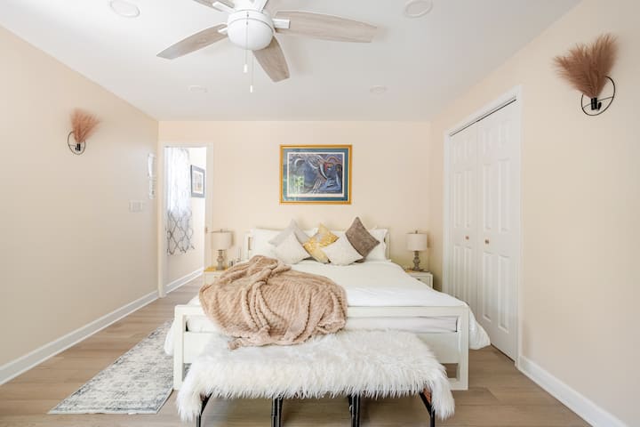 Cama tamaño king con calefacción y ropa de cama blanca suave, cortinas opacas y comodidad durante todo el año.