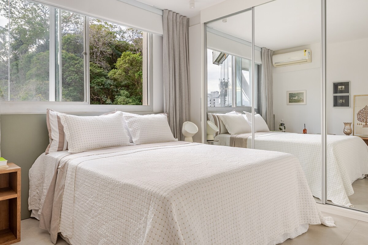 Slaapkamer met queensize bed, grote kast met spiegelde schuifdeuren en gemotoriseerd verduisteringsgordijn, en naast de slaapkamer een kast vol ruimtes.