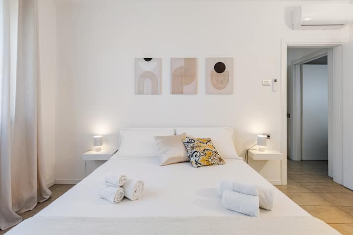 Amplio dormitorio con cama tamaño queen, selección de almohadas y TV, perfecto para una noche de sueño relajante. Equipado con aire acondicionado.