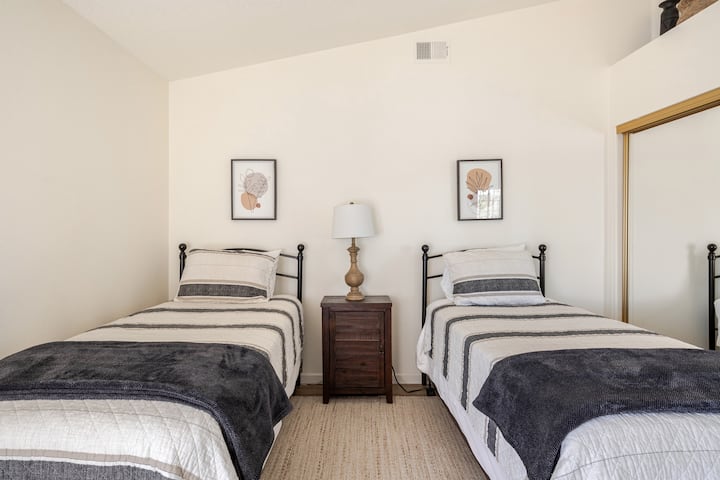 The den, off the main living room area, includes two twin beds, a closet, and a dedicated workspace.