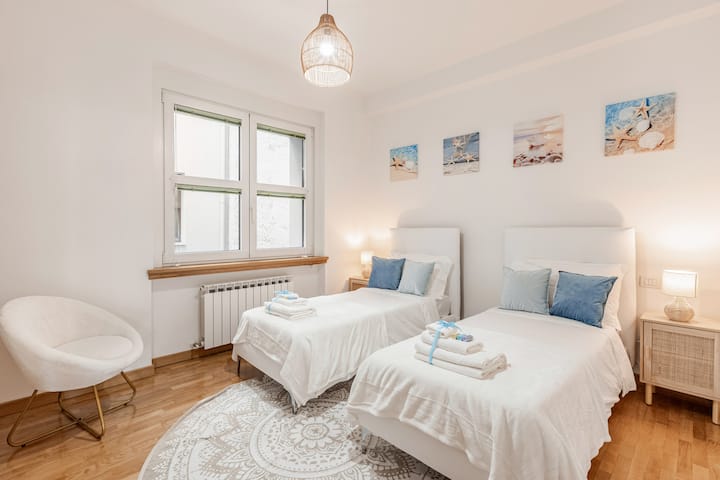 Twin room with bedside tables, lampshades and relaxing marine details 