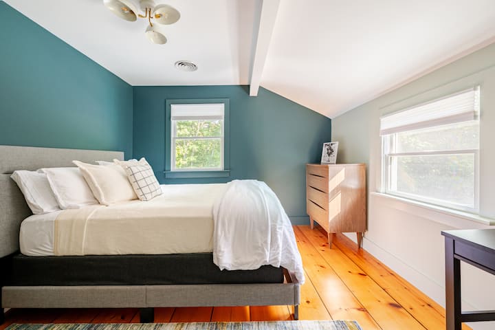3rd bedroom with queen bed and nightstand, views out to the backyard. 