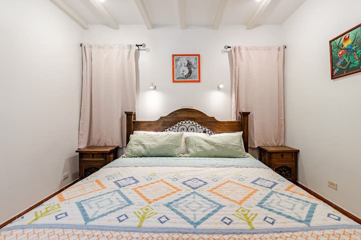 Chambre confortable avec un lit king size et un éclairage doux, offrant un espace calme pour se reposer après une journée à la plage.