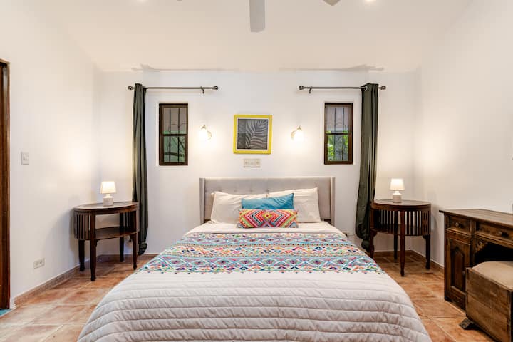 Chambre lumineuse et élégante avec un lit queen size, parfaite pour se détendre après une journée à explorer Playas del Coco.