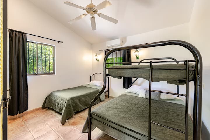 Chambre familiale avec un lit queen size et un lit superposé, parfaite pour les enfants ou les séjours partagés.