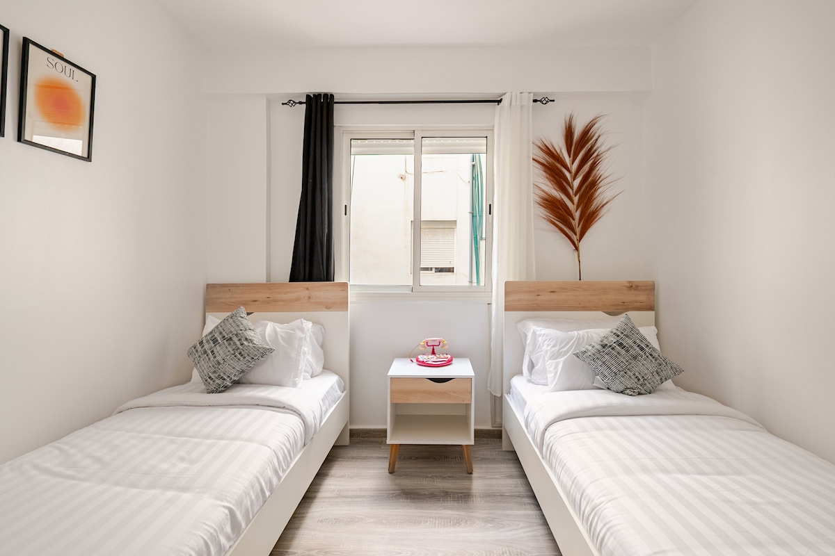 Habitación luminosa con dos camas separadas, idealmente pensada para recibir niños o amigos, en un espacio cómodo con una decoración sencilla y relajante.