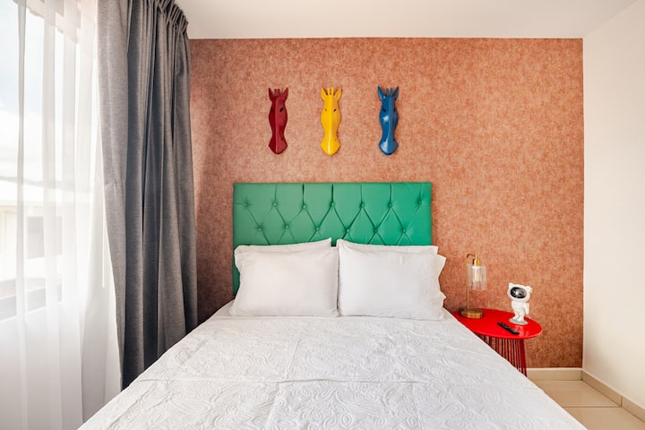 เตียงนุ่มสบายพร้อมหัวเตียงสีเขียวมรกต โคมไฟข้างเตียงมีพอร์ต USB ช่วยให้ชาร์จอุปกรณ์ได้ง่ายๆ ส่วนโปรเจคเตอร์รูปนักบินอวกาศก็ช่วยสร้างบรรยากาศสนุกสนานยามค่ำคืน