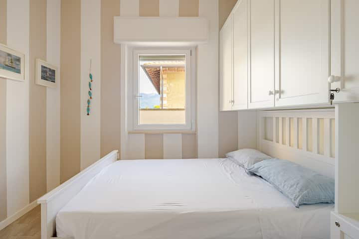 Habitación con un diseño moderno y alegre, con pared a rayas y una cama francesa. Ideal para parejas o jóvenes.