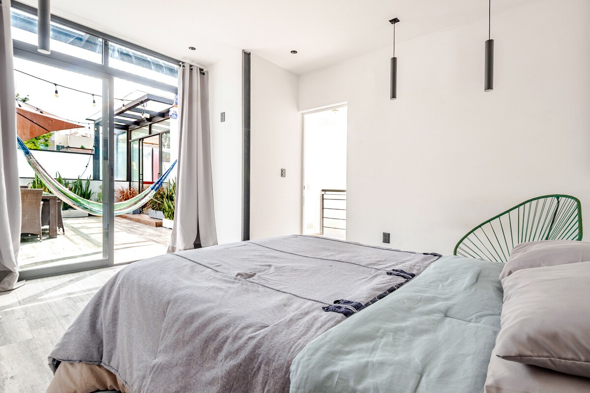 เราชอบห้องนี้เพราะมีทางเข้าสวนบนดาดฟ้า เพลิดเพลินกับวันที่มีแสงแดดและค่ำคืนที่สดชื่น เปลญวนอยู่ด้านนอก เป็นจุดที่สมบูรณ์แบบ 