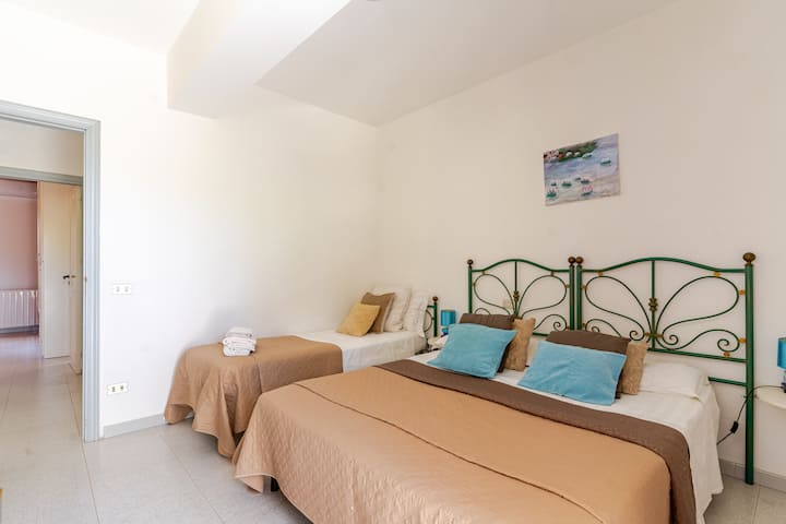 The room is equipped with a double bed and a single bed, a wardrobe with 2 doors. The private balcony offers an amazing view of the garden and the sea, creating a relaxing and welcoming atmosphere for a perfect stay.