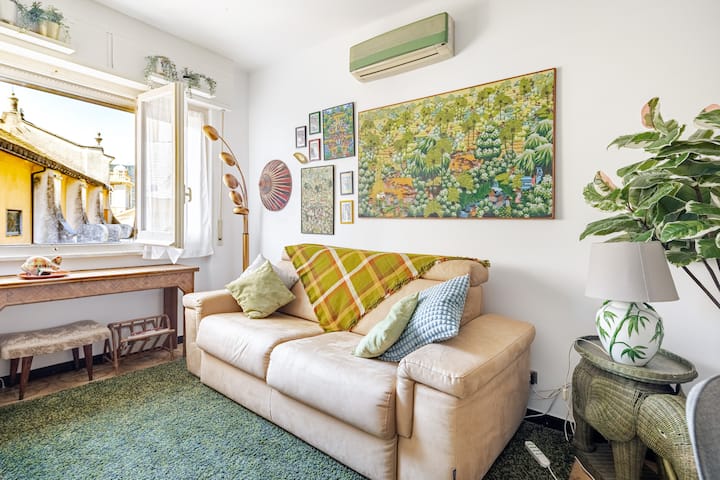 Sala de estar con sofá cama tamaño queen, aire acondicionado y una bonita vista de la ciudad.