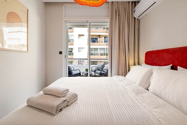 Segundo dormitorio con cama doble, ropa de cama de calidad hotelera, aire acondicionado y acceso directo al balcón amueblado.
