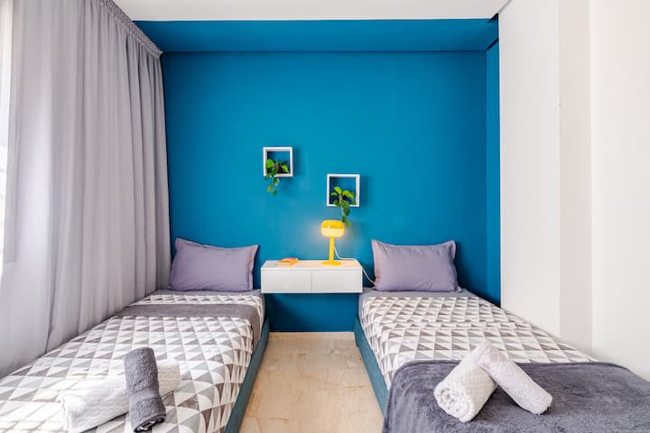 Hier is je SEO-vriendelijke beschrijving:

Tweepersoonskamer met twee eenpersoonsbedden, een opvallende blauwe accentmuur en een speelse, moderne inrichting. Schone handdoeken worden verstrekt. Ideaal voor vrienden, broers en zussen of soloreizigers die op zoek zijn naar een levendig, comfortabel verblijf.