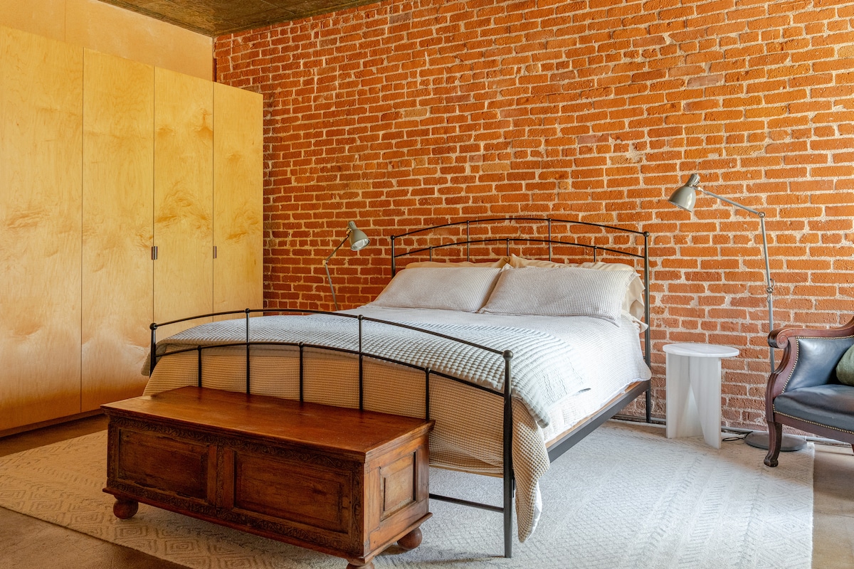 เตียงคิงไซส์พร้อมผนังอิฐดินเหนียวสีแดง