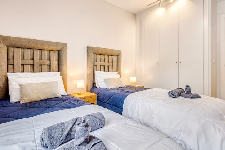 Comfortable bedroom with flexible twin or king setup and 50 inch TV for a relaxing stay