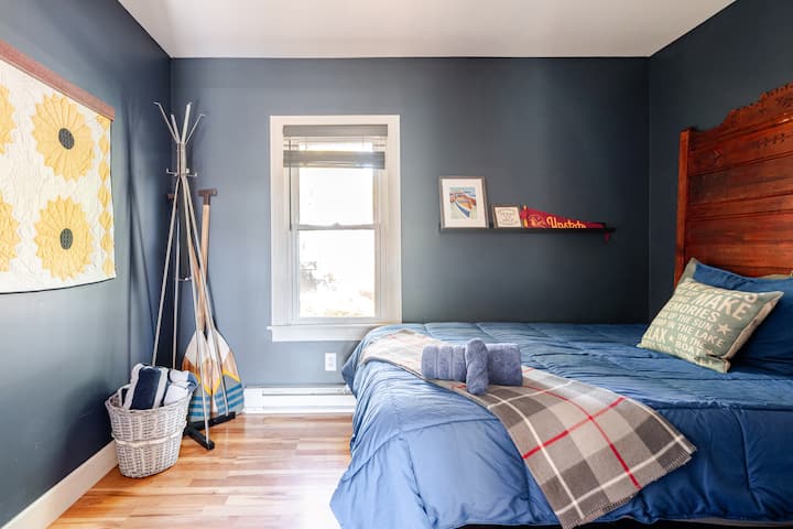 Comfortable full-size bed with soft bedding and a coat rack to make you feel right at home