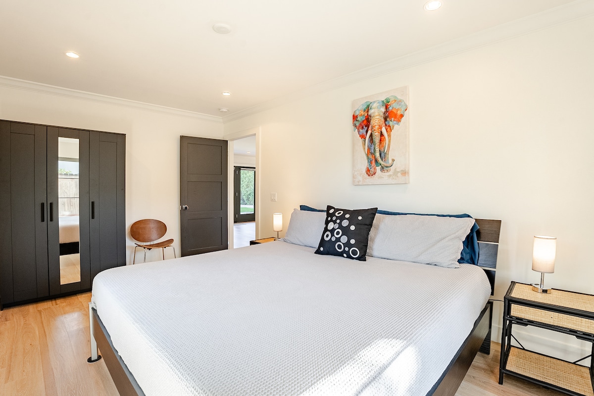 في الصورة: سرير بحجم كبير، ومنضدتان ليليتان مع مصابيح (محطة شحن داخل المصابيح )؛ خزانة تخزين ملابس مع مرآة خلع الملابس ؛ كرسي