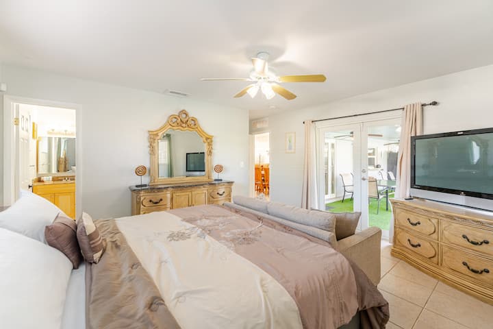 חדר השינה הראשי כולל מיטת קינג סייז, סוויטה פנימית, ספה, טלוויזיית HD וגישה ישירה לבריכה/פטיו