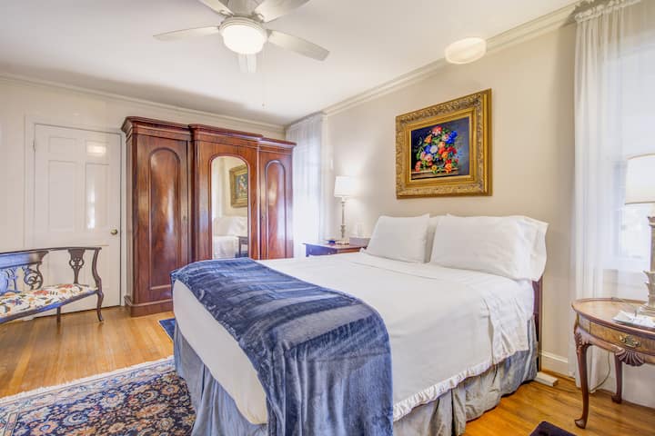 Camera da letto matrimoniale con letto matrimoniale, armadio d'antiquariato con armadio doppio e cassetti.