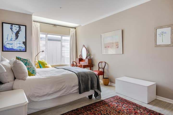 Cama tamaño queen en dormitorio soleado orientado al norte.