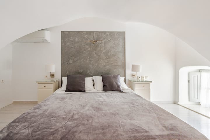 El dormitorio de la suite Kallisti Deluxe Split Level con vistas a la caldera y al mar se encuentra en el piso superior.