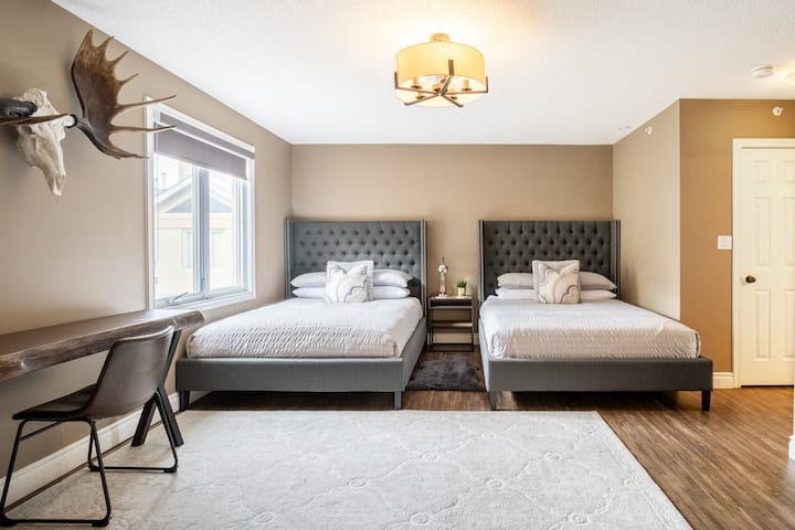Bedroom with 2 Queen Beds, work table, sitting area and ensuite. Pack n Play in the closet