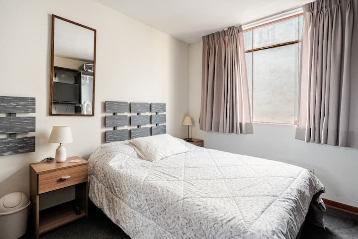 Chambre principale avec lit double, bureau et télévision
