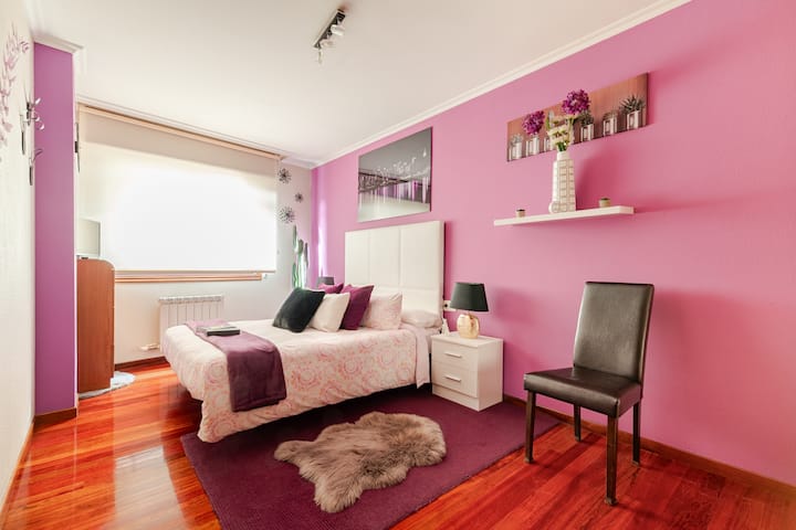 חדר נעים בגווני לילך עם מיטה 1.50, טלוויזיה עם גישה לנטפליקס, מצעים נוספים ועיצוב אופנתי, שנועד להציע מנוחה ונוחות בסביבה מודרנית ומרגיעה.