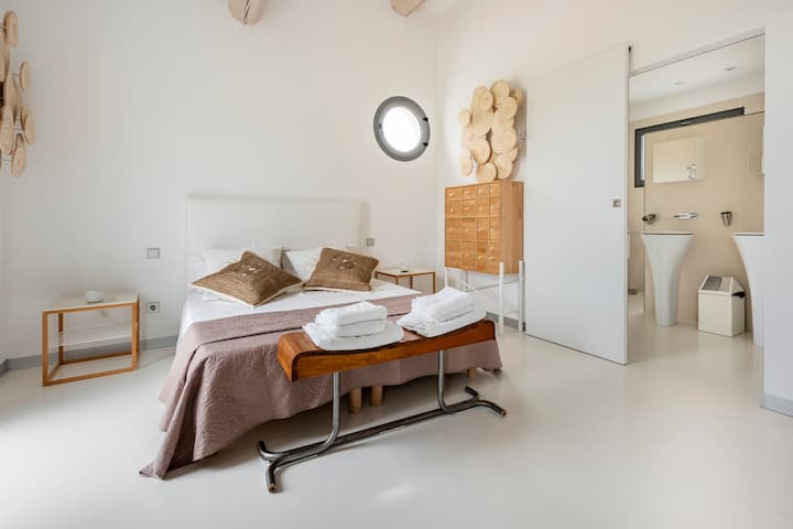 Chumba kikubwa angavu chenye televisheni kinachoangalia bafu, choo cha kujitegemea na chumba cha kupumzikia chenye kiyoyozi huru