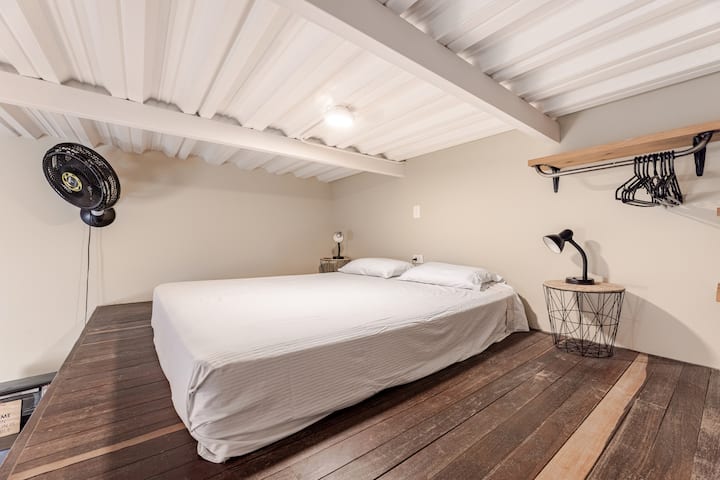 Mezanine media altura con cama Queen con ventilador, closet y luces de noche.