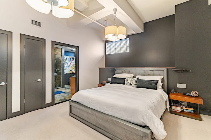 The second king bedroom with premium Casper California King mattress sits on a metal Restoration Hardware bed frame and is flanked by two side tables with reading lights. An attached en suite bathroom with shower and dual vanities rounds out the room
