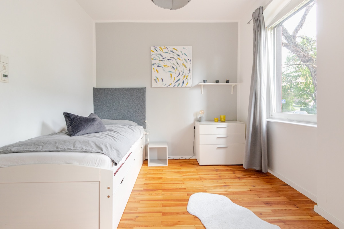 Bedroom 2 with 80s bed, small work area, wardrobe, an extra dresser and beautiful old real wood parquet that was newly refurbished in 2020