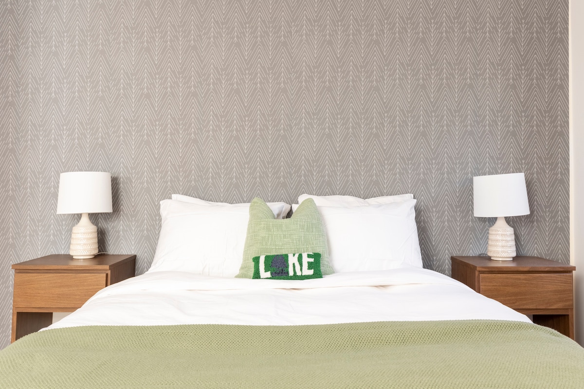 Main floor bedroom 4 with queen bed, full length mirrored closet doors, dresser and a variety of board games