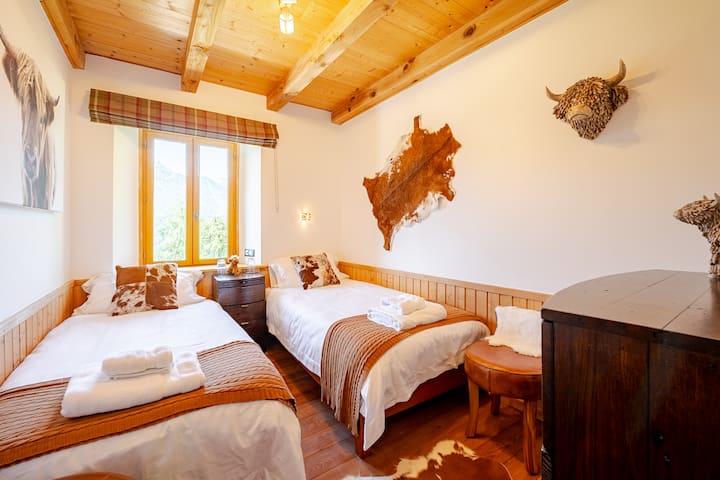 Habitación doble con vistas a la montaña orientada al sur. Toallas, batas y secador de pelo.