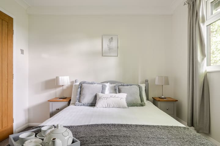 Chambre avec lit double, coiffeuse, sèche-cheveux et armoire double.