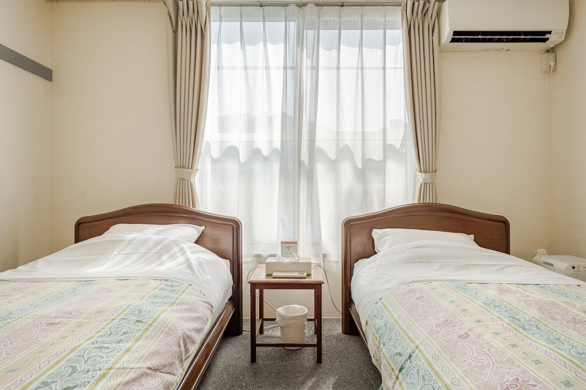 清潔感のある寝室はシングルベッドが2台あります。柔らかな陽が差し込む寝室です。