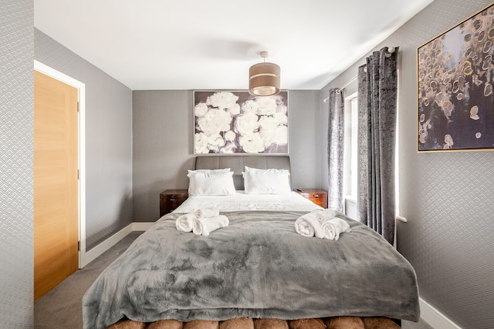 Chumba kikuu cha kulala kilichoonyeshwa vizuri chenye chumba cha kulala na kitanda cha Queen. Kabati lenye vioo viwili na hifadhi ya kutosha ya droo. Televisheni.