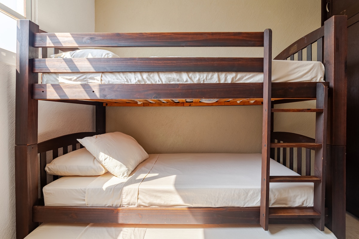 Recámara con 3 camas individuales, closet, ventilador y aire acondicionado.