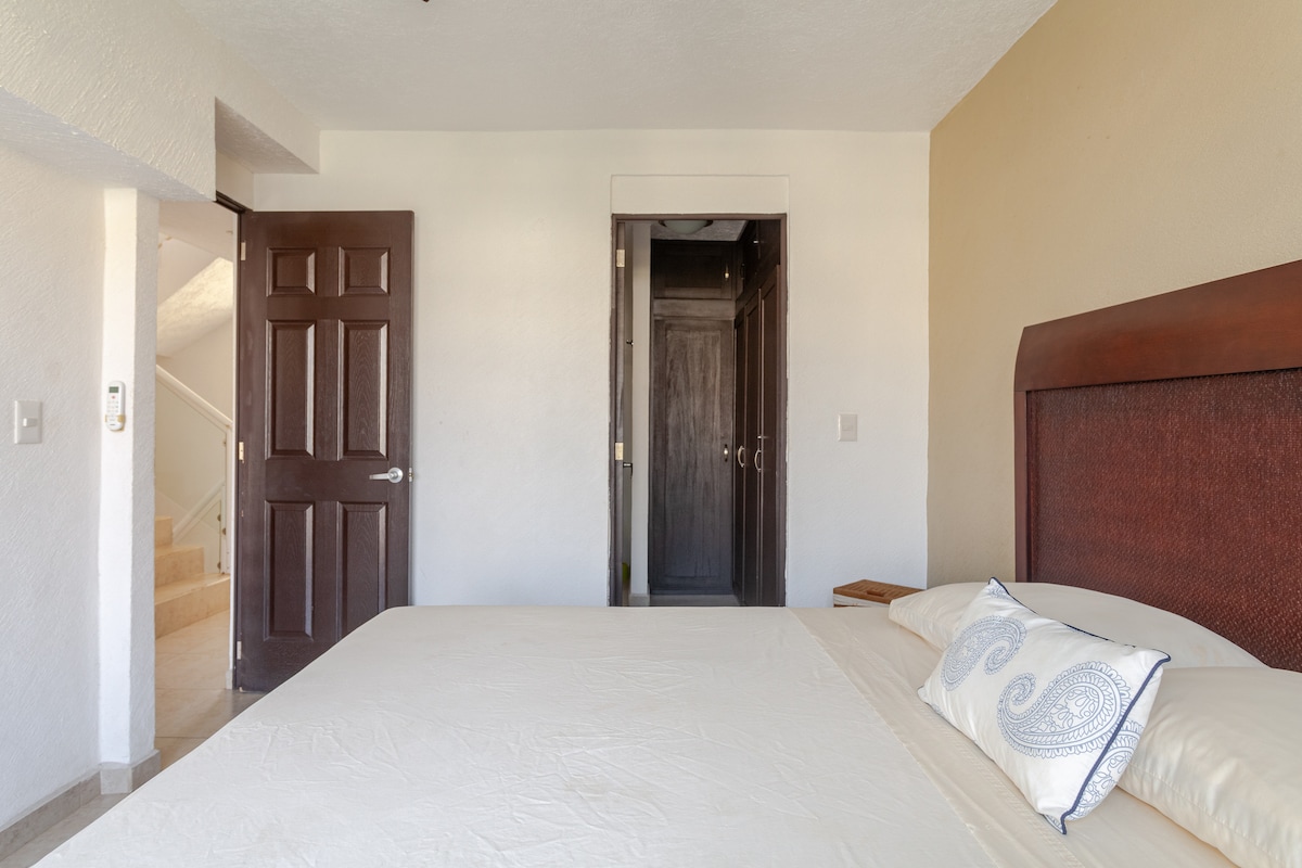 Recámara principal con cama kingsize y una individual debajo. Baño completo adentro con vestidor. Aire acondicionado y ventilador. Terraza privada con vista a la alberca y a las áreas verdes.