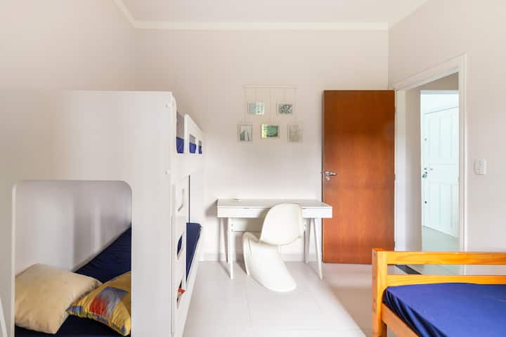 Dormitorio con una cama individual y una litera. Tiene aire acondicionado, armario y un espacio de oficina en casa.