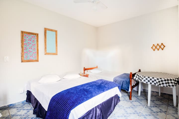 家庭套房位于起居区，配有一张双人床和两张单人床 