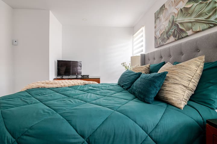 Soveværelse 1 (stueetagen): Hyggeligt soveværelse med queensize-dobbeltseng, masser af naturligt lys, en rummelig kommode og et smart-tv med kabel, Netflix, Prime Video og Disney+ – alt sammen for at sikre et afslappende ophold med ro og hvile