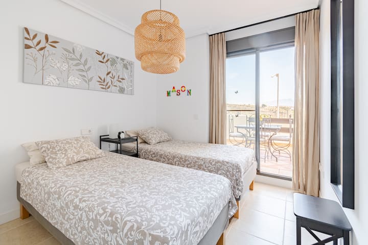 Tweede slaapkamer voorzien van twee losse bedden die gemakkelijk tot een groot tweepersoonsbed kunnen worden opgemaakt. Deze slaapkamer heeft direct toegang tot het terras aan de voorzijde van de woning.