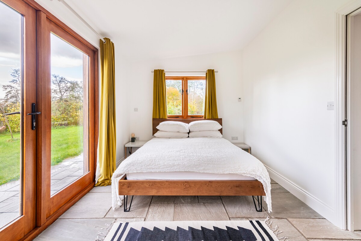 楼下有一间漂亮的卧室，配有一张大双人床。 您可以通过卧室的华丽双门直达花园通道。 