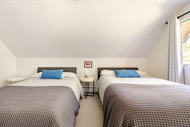 Bedroom 2 — Forest View: Three full beds with blackout curtains, smart TV, AC, ceiling fan, and closet. Ideal for kids or close friends.