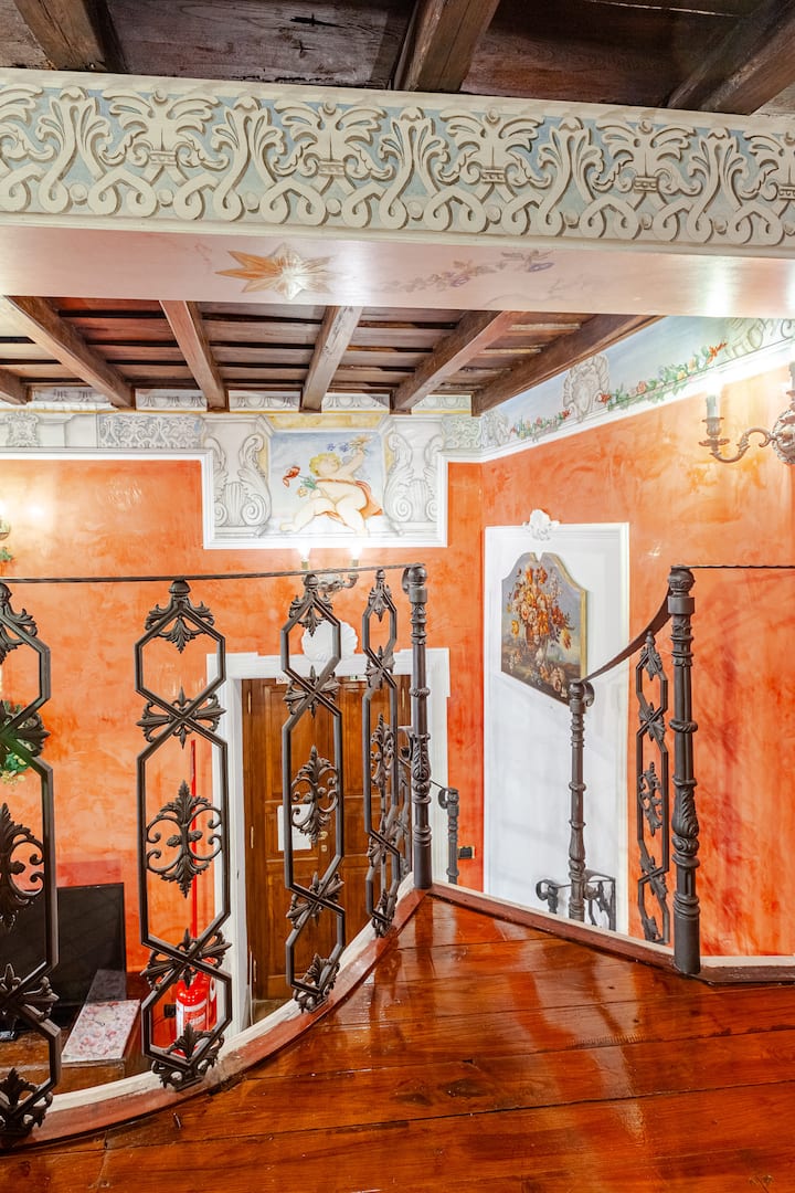 In detail, the old cast iron staircase, handmade  about 100 years ago by a blacksmith, which leads from bedroom 1 (main room) to the wooden loft with living room. The wooden beams of the ceilings are ancient, the decorations are hand painted