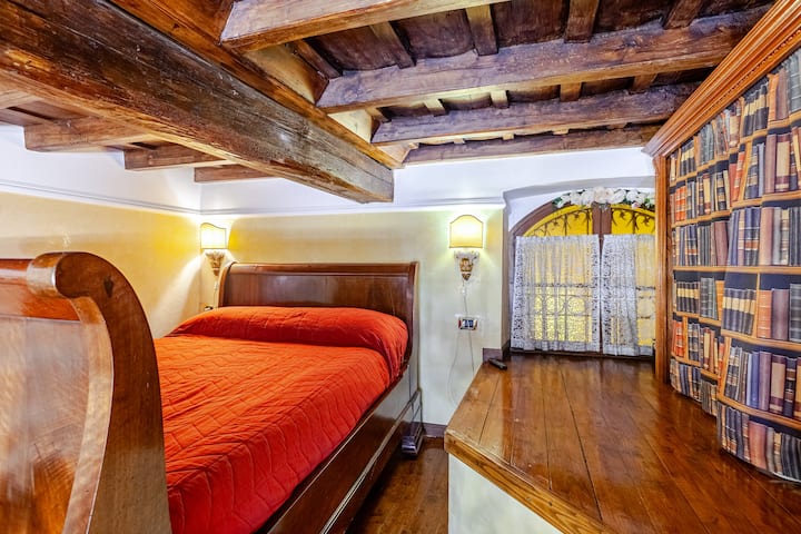 Loft (bedroom 2) with an antique wooden double bed (1800s). The wooden beams are ancient, the building of our apartment is from the 1700s. The bright abat-jours on the wall are ancient, handmade by a craftsman from Rome.